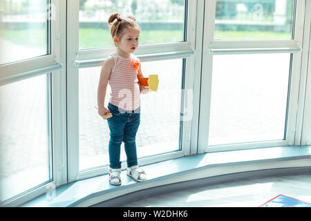 Hübsches nettes Mädchen stehen auf dem Fensterbrett Stockfoto