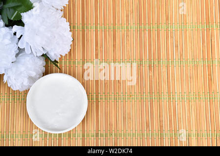 Kosmetik Schönheit Hintergrund mit Creme auf Bambus. Stockfoto