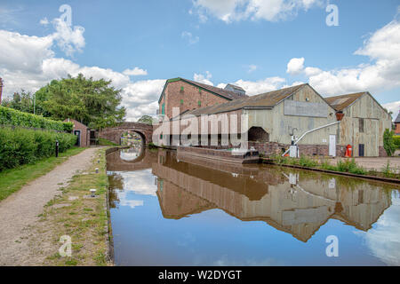 Blick entlang der Shropshire Union Canal in der Nähe von Market Drayton in Shropshire, Großbritannien, darunter auch Bridge 62 und Brücke 63 und der Talbot Wharf und Lastkähne Stockfoto