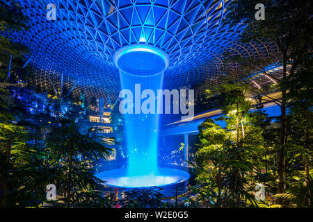 Nachtansicht Blaulicht-Display des Rain Vortex, größte und höchste Indoor-Wasserfall-Architekturstruktur, Jewel Changi Airport, Singapur. Stockfoto