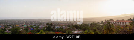 Antenne Panoramablick auf einem kleinen touristischen kubanische Stadt während einer bunten und bewölkter Sonnenuntergang. In Trinidad, Kuba genommen. Stockfoto