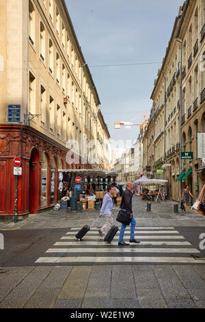 Zwei Männer mit Übernachtung Taschen zu Fuß gehen wie Marktstände werden am Tag der Umsatz von Rennes, der Hauptstadt der Bretagne, Frankreich Stockfoto