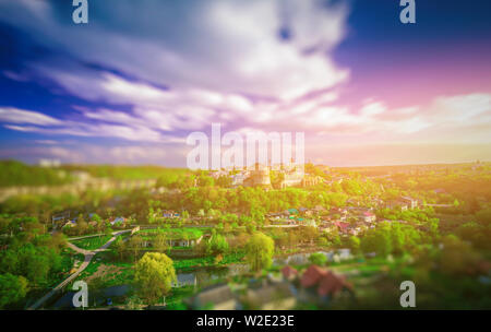 Super Tilt Shift Effekt Blick auf Dorf, grünen Bäumen und bunten Himmel mit Wolken Stockfoto