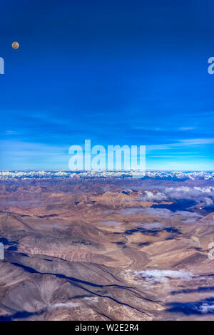Vollmond über die kargen Berge der Zanskar Spektrum der inneren Himalaja, Indien. Aus einem Flugzeug auf einem frühen Juli morgens genommen. Hochformat. Stockfoto