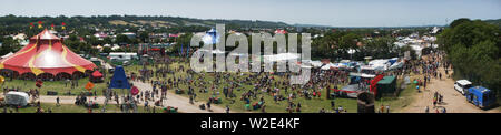 Ein fantastischer Panoramablick auf das Glastonbury Festival, das die riesigen Zeltstädte, weitläufigen Felder und die berühmte Landschaft zeigt Stockfoto