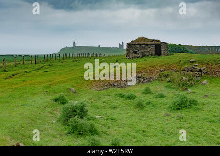 Weltkrieg zwei Pilllbox mit Dunstanburgh Castle in der Ferne, Northumberland, Großbritannien Stockfoto