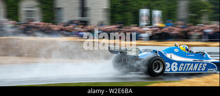 Spray fliegt von der Rückseite eines klassischen Ligier Formel 1 Rennwagen während einer nassen Morgen in Goodwood Festival der Geschwindigkeit 2019 Stockfoto