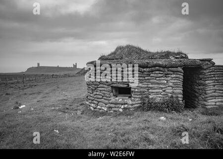 Weltkrieg zwei Pilllbox mit Dunstanburgh Castle in der Ferne, Northumberland, Großbritannien Stockfoto