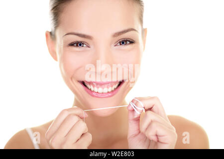 Zahnseide - Frau Zahnseide Zähne Lächeln glücklich mit perfekte Zähne und toothy Lächeln. Zahnpflege Konzept mit schönen Multirassischen asiatischen Kaukasischen weibliche Modell auf weißem Hintergrund. Stockfoto