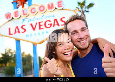 Las Vegas Paar glücklich und aufgeregt, am Willkommen im fabelhaften Las Vegas anmelden Billboard am Strip ab. Junge multirassischen Menschen asiatische Frau und kaukasischen Mann Spaß am Reisen in Las Vegas, Nevada, USA. Stockfoto