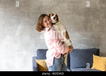 Der Eigentümer Lächeln und Umarmungen seinen Hund zu Hause. Stockfoto