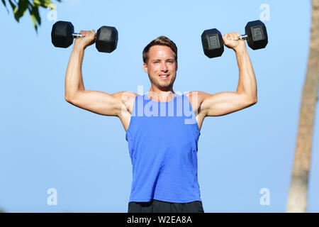 Fitness mensch Hantel Gewichte Ausbildung außerhalb. Fit muskulös männliche Gewichte in Schulter drücken Sie die Übung. Sport Modell Training im Freien im Sommer. Stattlichen kaukasischen Mann. Stockfoto