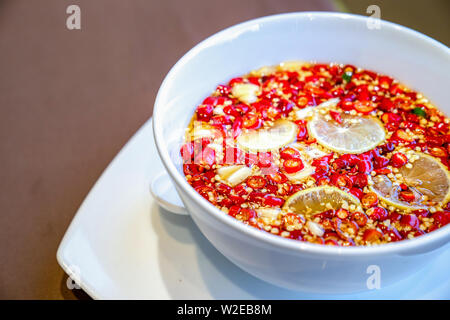 In der Nähe von Thai Sauce im traditionellen Stil. Chili Fischsauce mit Zitrone Limette und Knoblauch in weiße Schüssel. Stockfoto