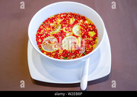 In der Nähe von Thai Sauce im traditionellen Stil. Chili Fischsauce mit Zitrone Limette und Knoblauch in weiße Schüssel. Stockfoto