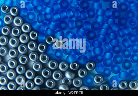 Nahaufnahme des silberfarbenen und blauen Glasperlen auf einer Platte Stockfoto