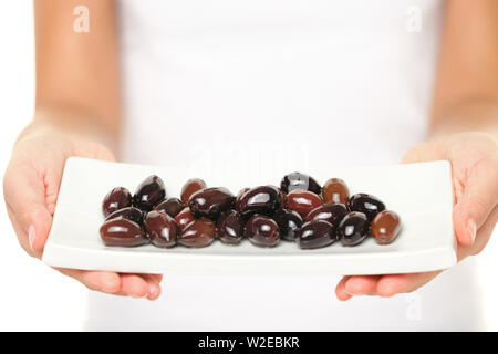 Oliven - Frau, Kalamata Olive Platte. Gesunde Snack für zwischendurch Schuß im Studio mit geringer Tiefenschärfe. Mediterrane Speisen. Stockfoto