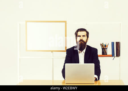 Überrascht bärtigen Geschäftsmann in Schwarz classic Anzug arbeiten mit Laptop im Büro Stockfoto