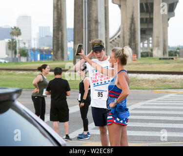 Läuferin nimmt ein smart phone selfie vor Beginn der 2019 Vier für das 4./4 km Fun Run in Corpus Christi, Texas USA. Stockfoto