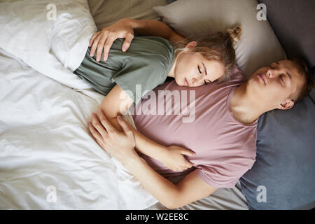 Ruhigen jungen Eheleuten in t-shirts schlafen in der Nähe von einem anderen unter Vertrag bei Nacht Stockfoto