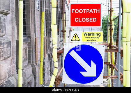 Wanderweg geschlossen Männer Arbeiten über Kopf Warnschild Stockfoto