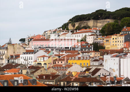 Blick von der Arco da Rua Augusta über die Dächer von bunten Gebäude im Stadtzentrum von Lissabon, Portugal zu den alten historischen Mauern von der Burg Stockfoto