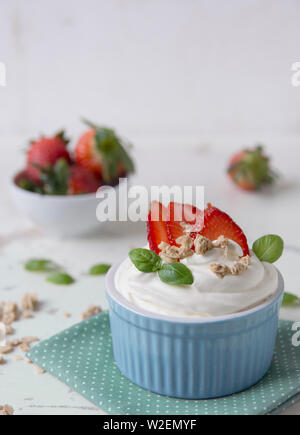 Tasse Eis mit Sahne Erdbeeren Blätter der Kräuter mit pastellfarbenen Stockfoto