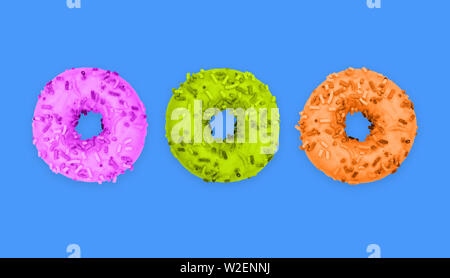 Drei mehrfarbige Donuts auf blauem Hintergrund. Süße Krapfen in der Vereisung. Design für Frühstück, Café, Bäckerei. Kreativen Stil. Fast Food Stockfoto