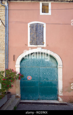 Alte Türkis Garagentor & Orange Fassade des alten Haus im Dorf Goult Luberon Provence Frankreich Stockfoto