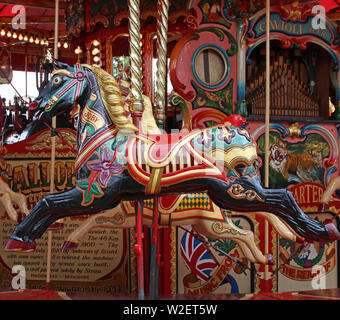 Schwarz und Gold hoch dekorierte traditionelle Fairground galoppierende Pferde Stockfoto