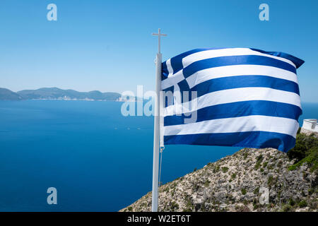 Griechische Fahne fliegt über das Ionische Meer in Kefalonia, Griechenland Stockfoto