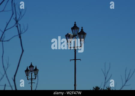 Paar oder Alte Triple Lamp Beiträge auf der Brücke von Don vor blauem Himmel. Winter, Aberdeen, Schottland, Großbritannien. Stockfoto