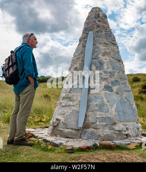 Älterer Mann an konischen Stein Skulptur mit dem Flugzeug propellor suchen, John Muir, Her von Forth, East Lothian, Schottland, Großbritannien Stockfoto