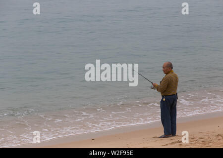 Alter Mann angeln am Meer, Tung Wan Stockfoto