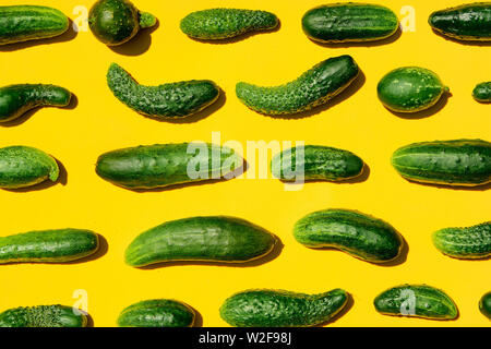 Verschiedenen Größen formen Gurken Muster auf einem gelben Hintergrund. Kopieren Sie Platz. Gurken Hintergrund close-up. Ansicht von oben. Gurke Ernte. Gurken Stockfoto