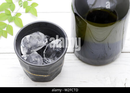 Flasche Japanische shochu und keramische Schüssel auf hölzernen weissen Tisch Stockfoto