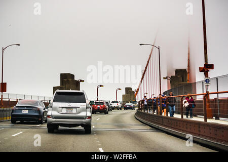 Juli 4, 2019 San Francisco/CA/USA - Fahrt auf der Golden Gate Bridge an einem nebligen Tag; es ist eine Suspension Brücke über die Golden Gate, das - Stockfoto