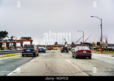 Juli 4, 2019 San Francisco/CA/USA - Fahren auf dem Weg zur Golden Gate Bridge und der Golden Gate Bridge im Nebel sichtbar, im Hintergrund Stockfoto