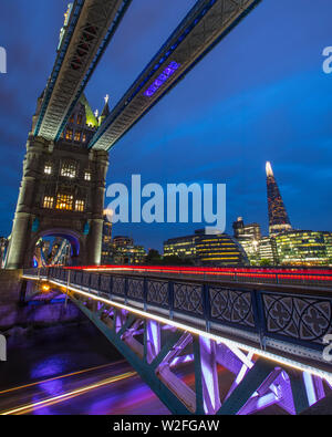 Einen atemberaubenden Blick auf die Tower Bridge in London, UK. Leichte Wanderwege vom Boot aus gesehen werden kann, die unter der Brücke sowie leichte Spuren von Luftverkehr werden Stockfoto