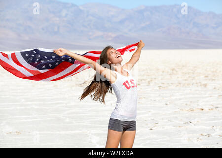 USA-Flagge-Sportlerin, die amerikanische Flagge. US Sport Athleten Gewinner zujubeln winken Sterne und Streifen draußen in der Wüste Natur. Schöne Jubel glückliche junge multikulturelle mädchen freudig aufgeregt. Stockfoto