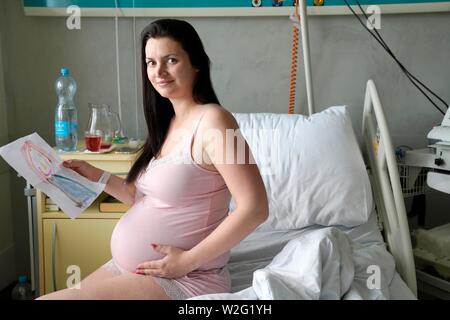 Schwangere Frau sitzt auf dem Krankenbett in sickroom, risikoreiche Schwangerschaft, Karlovy Vary, Tschechische Republik Stockfoto