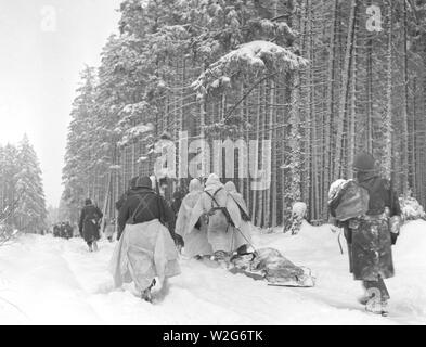 Originale Bildunterschrift: Die amerikanischen Truppen ziehen einer schwer beladenen Munition Schlitten durch den Schnee, da sie bei einem Angriff auf Herresbach, Belgien bewegen. 1/28/45. 1 Mrd., Co.C., 325 Glider Reg't., 82 A/B Div. Stockfoto