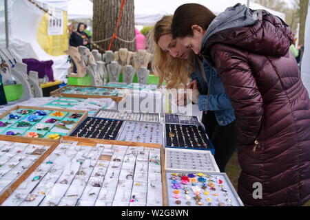 Meriden, CT USA. Apr 2019. Narzissenfest. Junge Frauen, die versuchen, auf Schmuck konzentriert. Stockfoto