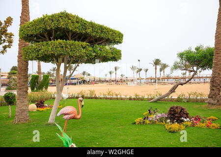 Hurghada, Ägypten bis zum 15. April 2019: Bilder von einem Weg durch den Garten mit Blumen und einem dekorativen Statue eines Vogels Stockfoto