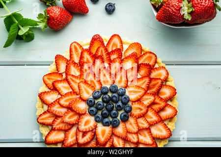 Kuchen mit Beeren Torte mit Erdbeeren und Blaubeeren auf Blau rustikal Tisch. Stockfoto