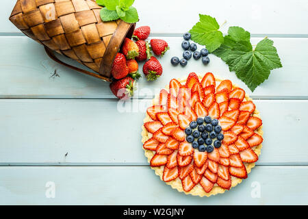 Kuchen mit Beeren Torte mit Erdbeeren und Blaubeeren auf Blau rustikal Tisch. Stockfoto