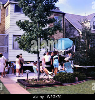 Menschen versammelt, um für eine Party auf einem Hinterhof Terrasse ca. 1965 Stockfoto