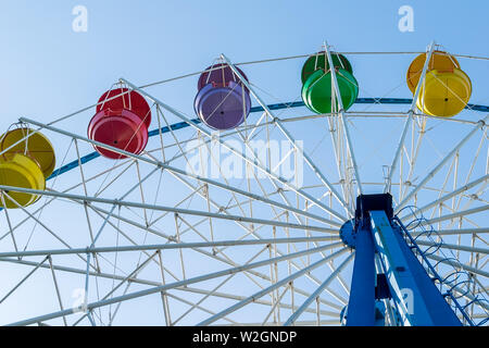 Riesenrad im Vergnügungspark mit bunten Körbe der Sitze gegen den blauen Himmel Stockfoto