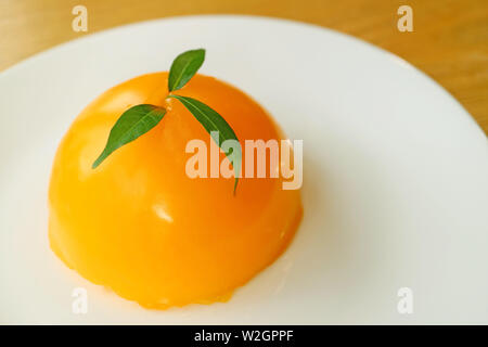 Lebendige Farben Mandarin Orange Kuchen Kuppel auf einer weißen Platte Stockfoto