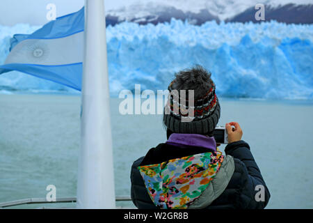 Weibliche Tourist, Fotos von der atemberaubenden Gletscher an der Wand des Gletschers Perito Moreno vom Kreuzfahrtschiff auf den Lago Argentino, Patagonien, Argentinien Stockfoto