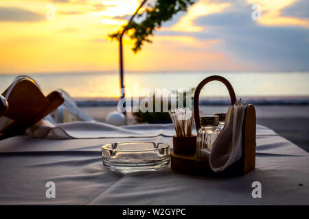 Stühle und Tisch in typische griechische Taverne in der Morgensonne mit Schatten. Stockfoto